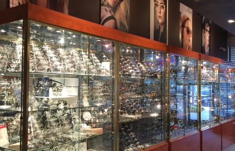 Glasses and sunglasses on display in cases in a glasses store.