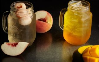 Lychee peach tea and mango sweet tea in mason jars.