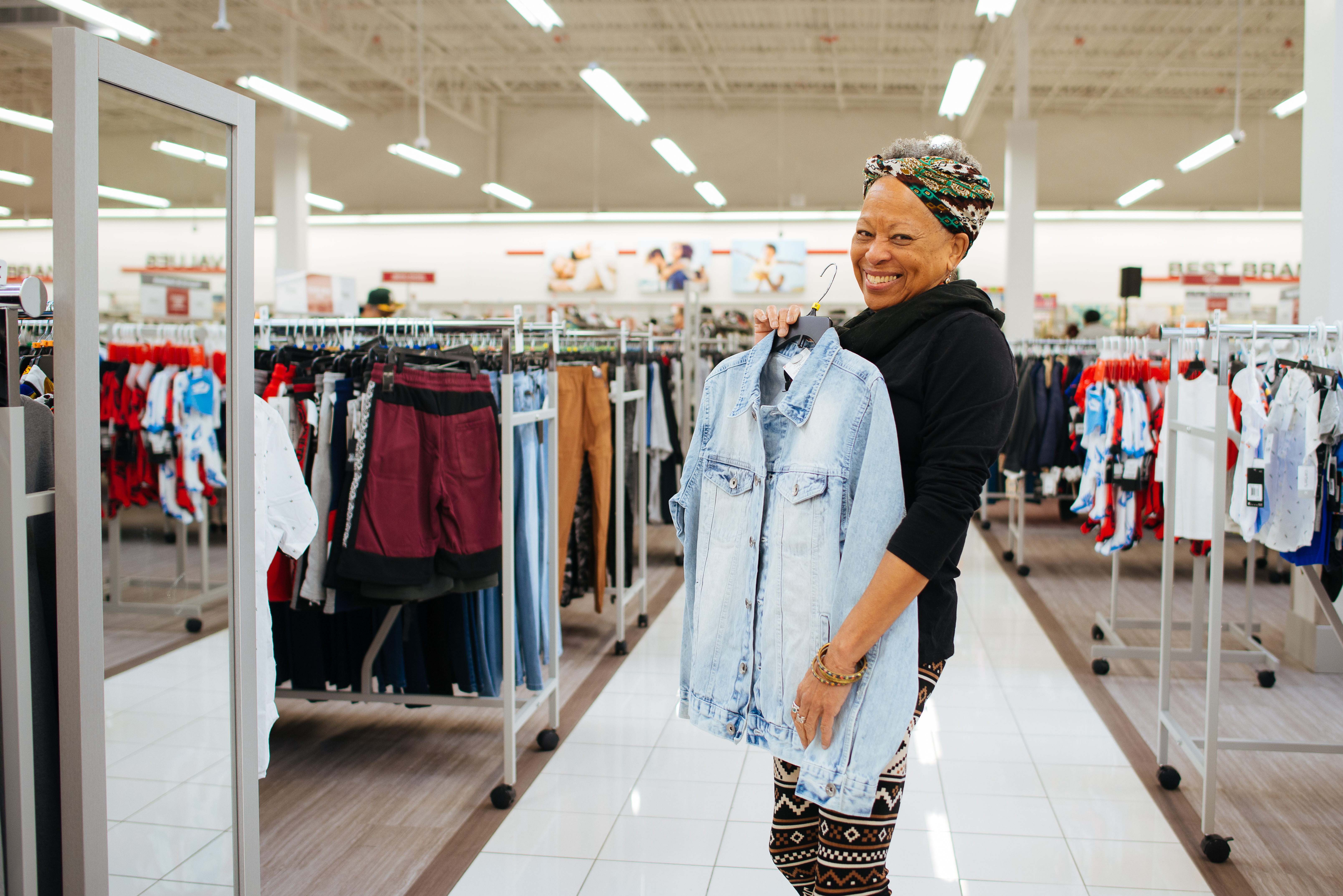 Woman excited about her denim jacket she will buy.